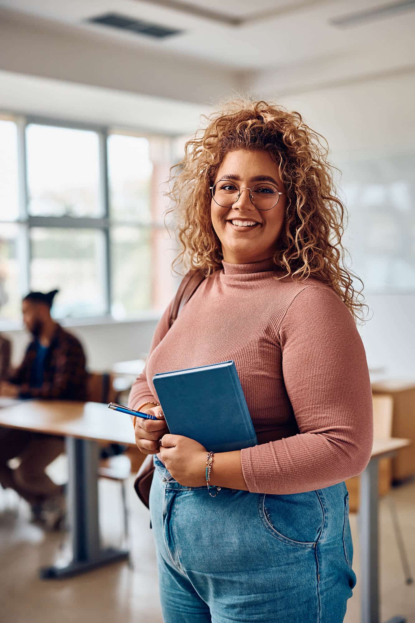 happy-female-student-standing-in-the-classroom-and-2023-11-27-04-56-53-utc.jpg